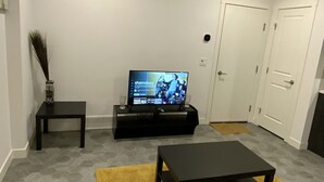 Ein Wohnzimmer mit Fernseher, Couch und Couchtisch.