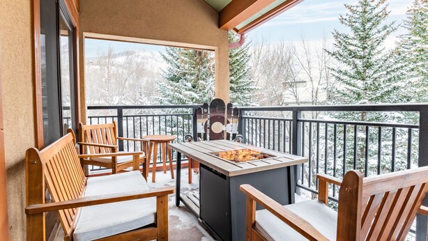A balcony with wooden chairs and a built-in grill. - Cloud 9 by AvantStay | Located at the Base of Vail Ski Resort w/ Fire Pit + BBQ (Vail)