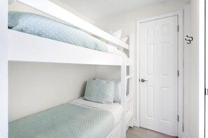 A bunk bed room with a white door and a small window. - 300 Feet from the Beach, Steps to the Seasonally Heated Pool - Cabana 111 at Gulf Place on 30A (Santa Rosa Beach)