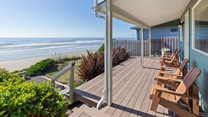 A wooden deck with chairs overlooking a beach. - Oceanfront- Sea Gem Cottage (South Beach)