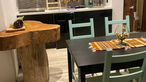 Una cocina compacta con gabinetes negros, un microondas integrado y un lavamanos pequeño.