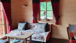 A cozy room with a bed, a table, and a window with curtains.
