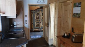 A compact kitchen with a coffee maker, toaster, and a wooden cabinet.