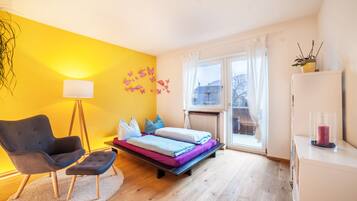 Ein Schlafzimmer mit Bett, Stuhl, Lampe und Fenster.