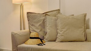 Ein beiges Sofa mit einem gewobenen Hut und zwei Kissen.