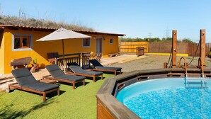 A pool area with lounge chairs and a small building with a door and windows. - Country House 'Casa Rural Los Colorados' with Mountain Views and Pool (Vega de San Mateo)
