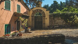 A rustic building with a stone wall, a wooden gate, and potted plants. - ‘Casa Conte Picedi Appartamento Luna’ Apartment with Sea View (Lerici)