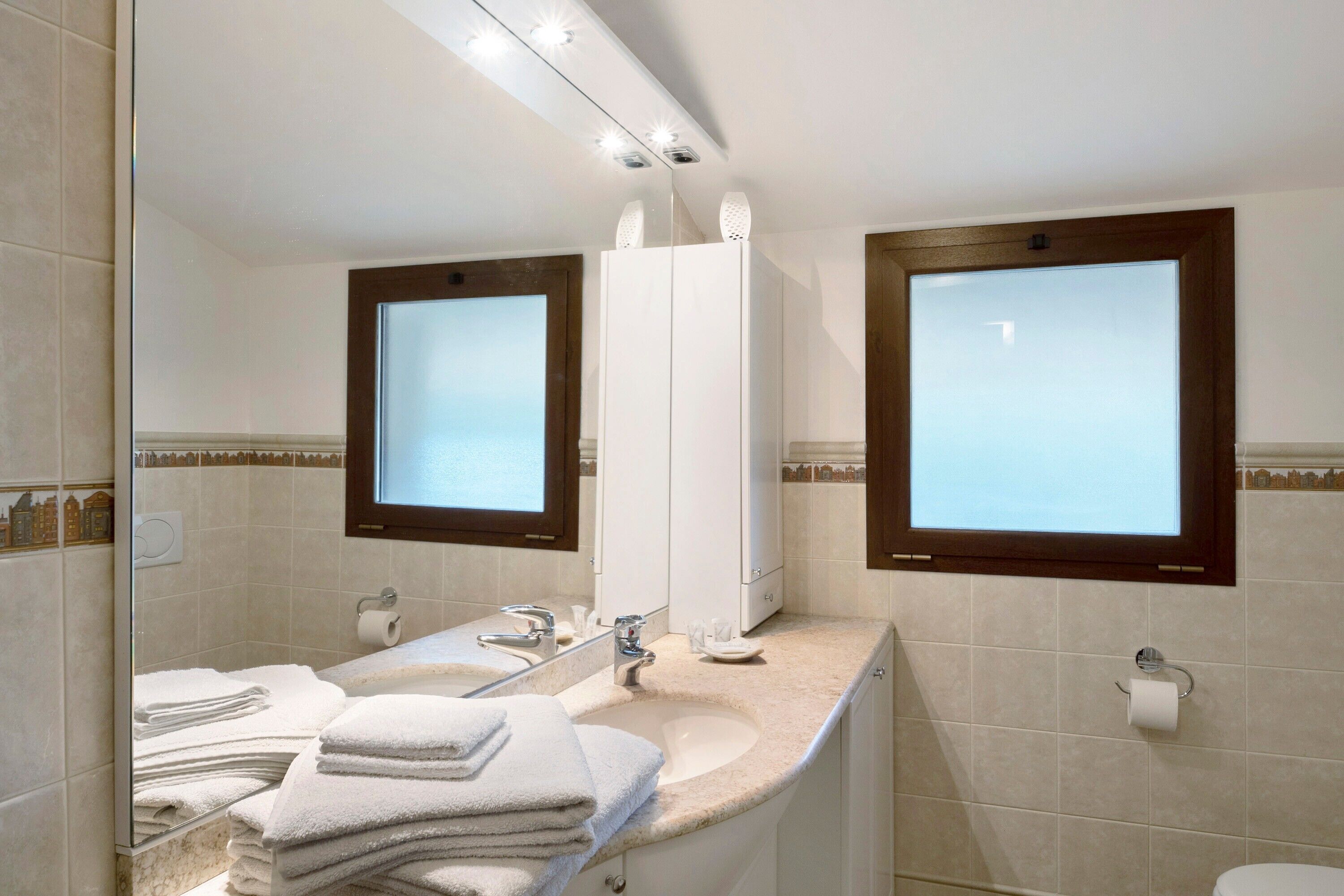 Un baño con lavamanos, espejo e inodoro.