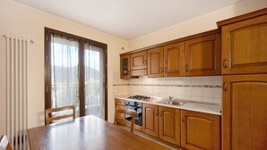 A kitchen with wooden cabinets, a stove, and a dining table.