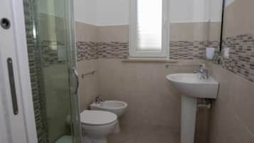 Een douche, een haardroger, een bidet, handdoeken