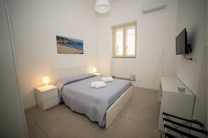 Cozy retreat with a neatly made bed, nightstand, and wardrobe, perfect for a restful stay.