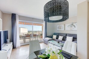 Relax in this serene hotel room with a balcony, dining table, and comfortable sofa.