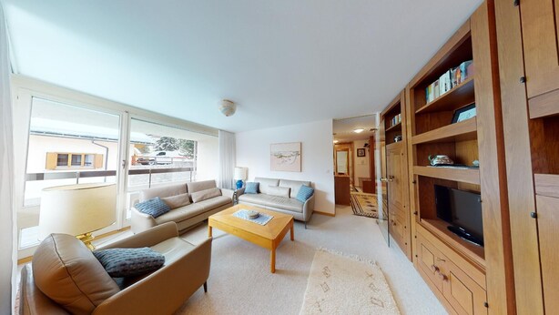 Una sala de estar moderna con un sofá, una mesa de centro y un mueble para la televisión.