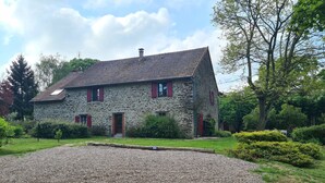 Ein Steinhaus mit Kiesweg und gepflegtem Garten.