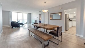 A modern apartment with a dining area, a living room, and a kitchen. - Great apartment in Hollywood with side ocean view! Direct exit to the beach! (Hollywood)