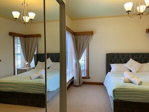 A hotel room with two beds, a large mirror, and a chandelier. - Beautiful scenery in Glenorchy with mountain and water view (Glenorchy)