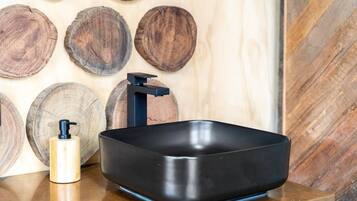 A black rectangular sink with a modern faucet on a wooden countertop.