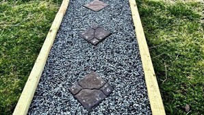 Un camí amb pedres que fan de graons porta a una zona d'estar amb seients.