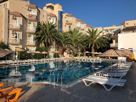 Una piscina al aire libre de temporada, sombrillas