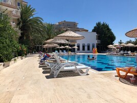Una piscina al aire libre de temporada, sombrillas