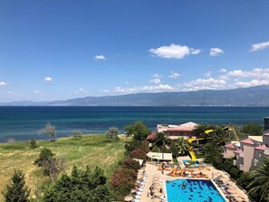 Et resort med swimmingpool, liggestole og havudsigt.