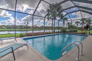 A swimming pool with a view of a lake and houses in the background.