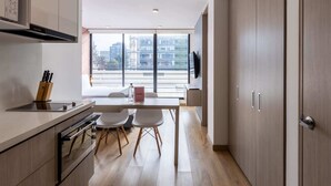 Une cuisine moderne avec un coin repas, de grandes fenêtres et une vue sur la ville.