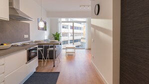 Eine moderne Küche mit Essbereich, einem großen Fenster und Blick auf die Stadt.