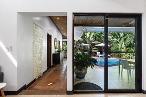 A modern interior with a glass door leading to an outdoor pool area.
