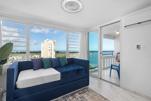 Enjoy a room with a large window offering a view of a high-rise building and the surrounding landscape.