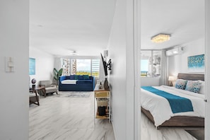 Relax in a spacious room with a large bed, bedside table, and stunning outdoor views.