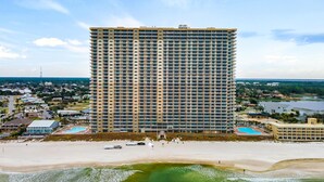 Un grand hôtel avec de nombreux étages, une plage et un espace piscine.