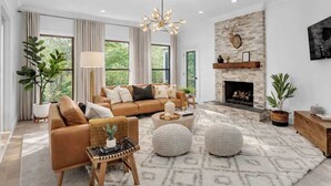 Un salon moderne avec une cheminée, un canapé en cuir et une grande fenêtre.