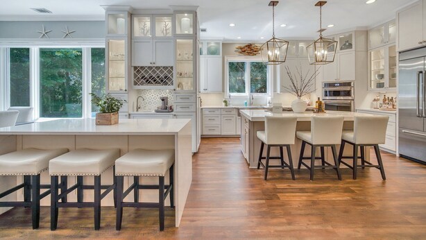 A modern kitchen with white cabinetry, a large island with bar stools, and a built-in oven. - PRIVATE Beach access, 4th Row, Heated Pool & Dog Friendly (Hilton Head Island)