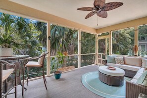 A sunroom with wicker furniture, a ceiling fan, and a view of lush greenery. - PRIVATE 4th Row Beach Access, Heated Pool & Dog Friendly (Hilton Head Island)