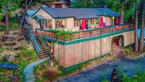 A two-story house with a covered porch, a staircase, and a small garden area.
