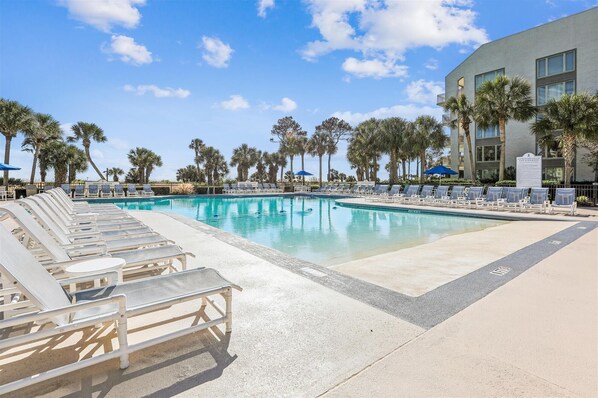 Relax by the pool surrounded by palm trees and enjoy the views from the adjacent building's balconies.