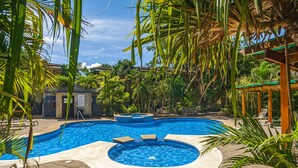 A swimming pool with a hot tub, surrounded by palm trees and lounge chairs. - Walk to Everything! 2BR Villa at Playa Penca - Pool, Parking + Massages on us! (Provincia de Guanacaste)