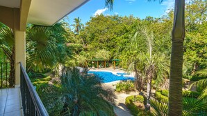 A pool area with a pergola, surrounded by lush tropical vegetation and palm trees. - Walk to Everything! 2BR Villa at Playa Penca - Pool, Parking + Massages on us! (Provincia de Guanacaste)