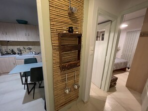 Een moderne keuken met houten keukenkastjes, een eettafel met stoelen en een wandpaneel van bamboe.