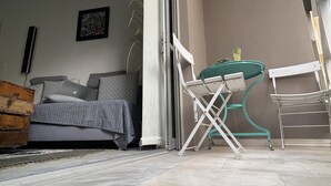 Un balcon avec un canapé, une table et des chaises.