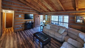 A log cabin interior with a sofa, a coffee table, a TV, and a wooden ceiling. - Villa Bonita/ Private Mountain top Cabin on 7.5 Acres w/Hot Tub (Sevierville)