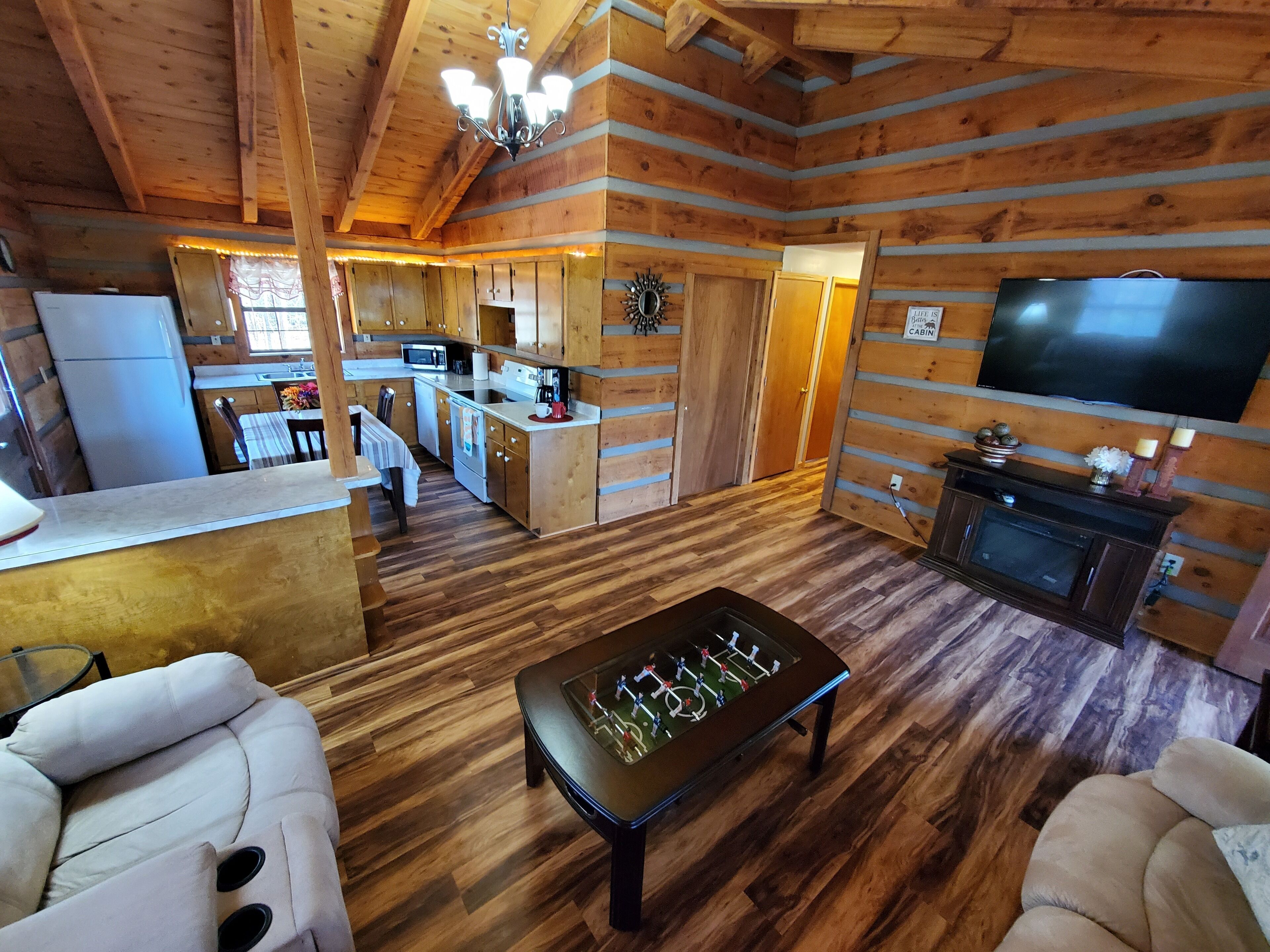 Un intérieur de chalet chaleureux comprenant une cuisine, un coin repas et un salon.