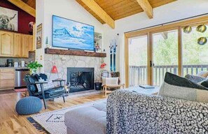 TV connectée, cheminée, livres, chaîne hi-fi