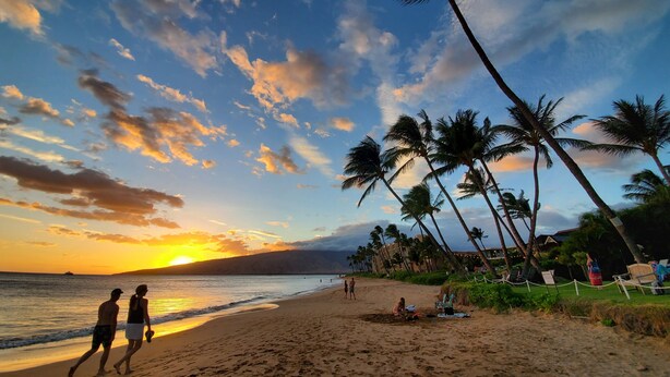 A beach with palm trees, a sunset, and a few people walking. - Summer Special Pricing!  Oceanfront · Private Lanai · Heated Pool · Sunsets (Kihei)