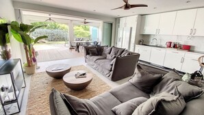 Una sala moderna con un sofá grande de color gris, una mesa de centro y un ventilador de techo.