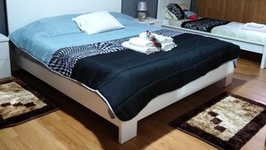 Une chambre à coucher avec un lit, des tables de chevet, une lampe et un plafond en bois.
