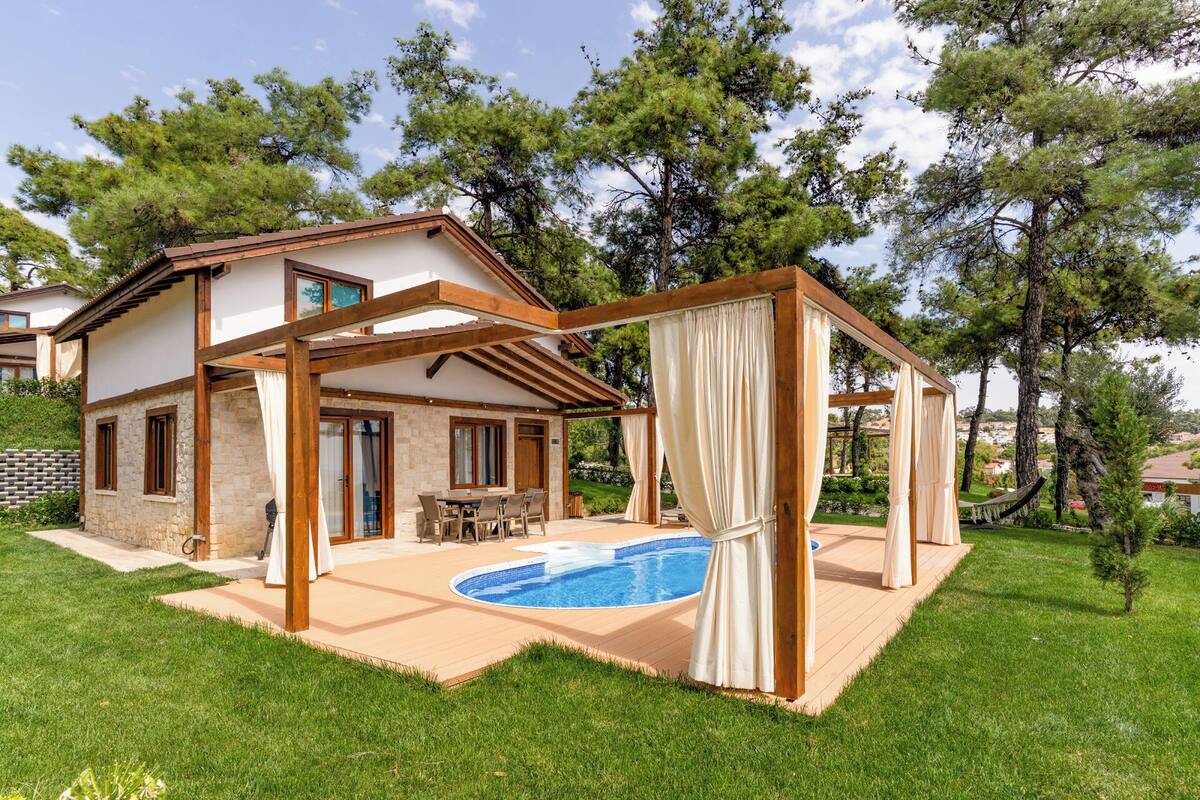 Ein Haus mit Pool, einer Pergola und einem Garten.