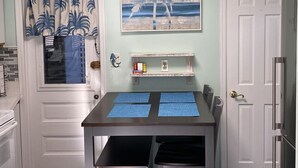 A kitchen with a dining table, chairs, a ceiling light, a door, and a wall with a painting. - Cozy Cottage 3 blocks to Town 7 to Beach 4 Blocks to Asbury (ocean grove)