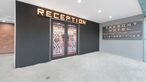 Zona de recepció d'hotel amb un disseny modern, que inclou una taula d'informació i un cartell amb la inscripció 'RECEPTION'.